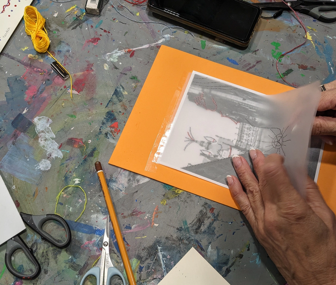 Hands embroidering on photo during workshop